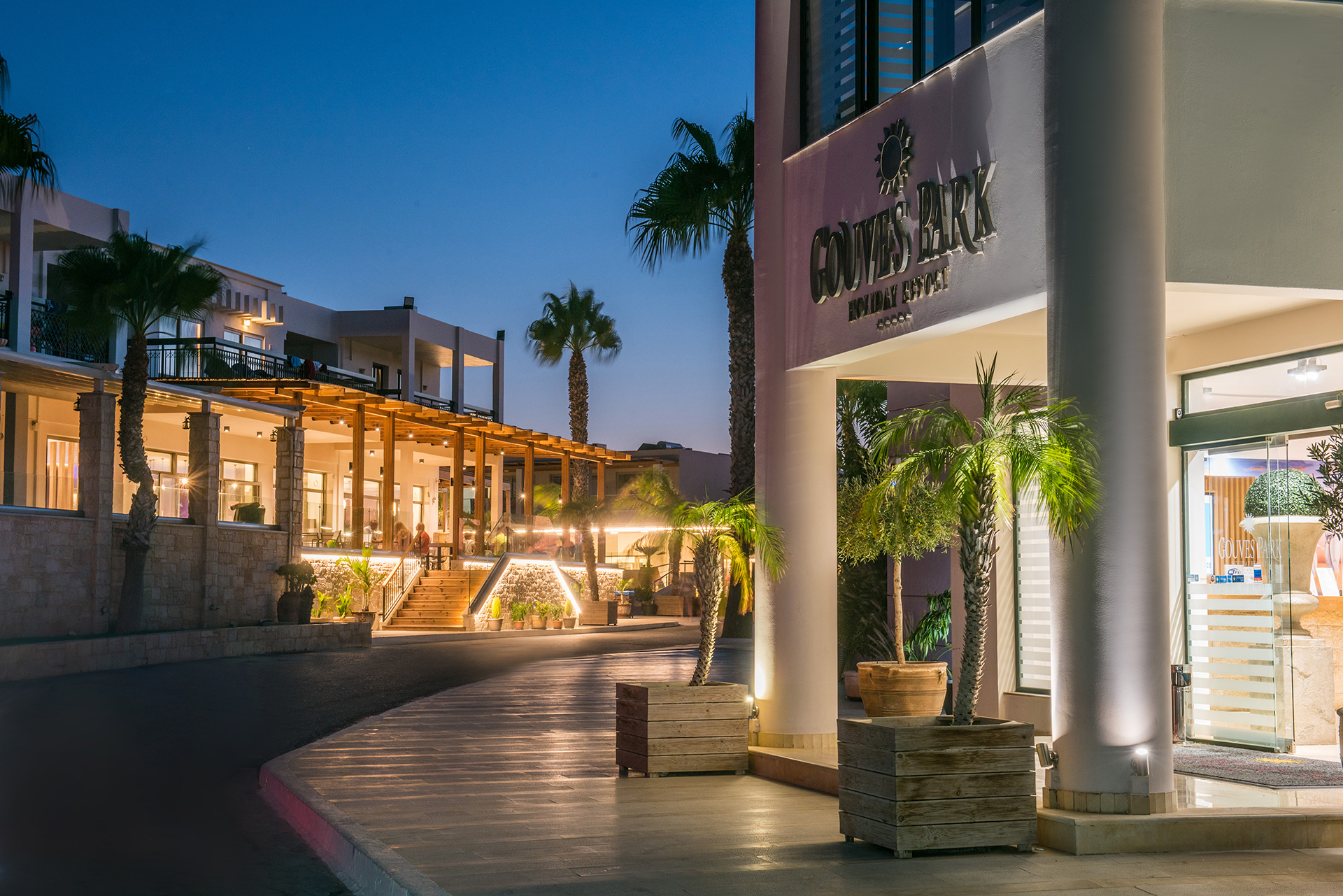Evening view of the illuminated entrance and reception area at Gouves Water Park Holiday Resort in Crete
