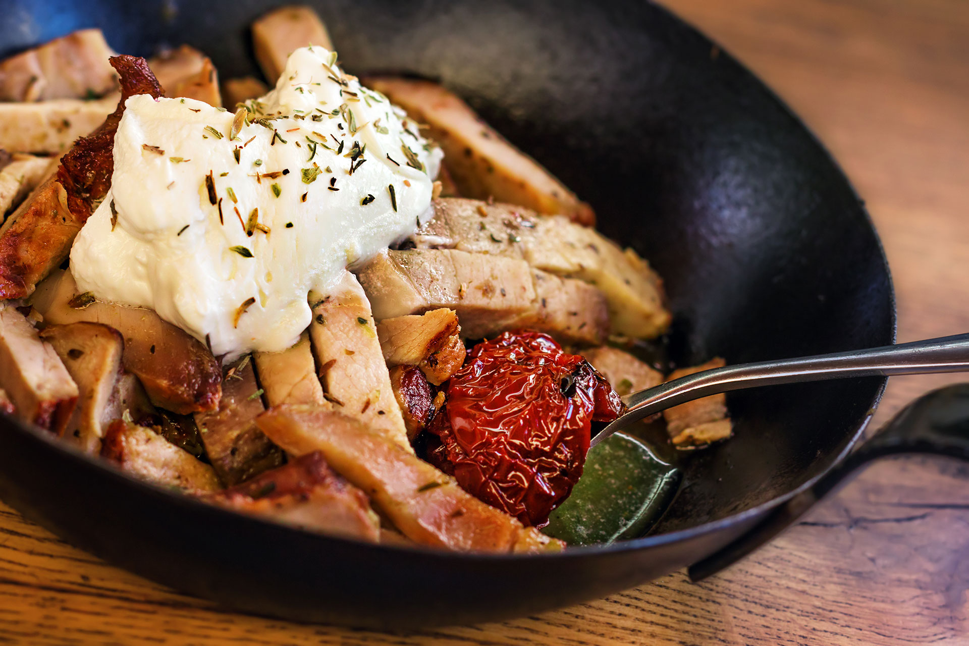 Pan of sliced meat served with yogurt, oregano, olive oil and sun-dried tomatoes at Gouves Water Park Holiday Resort